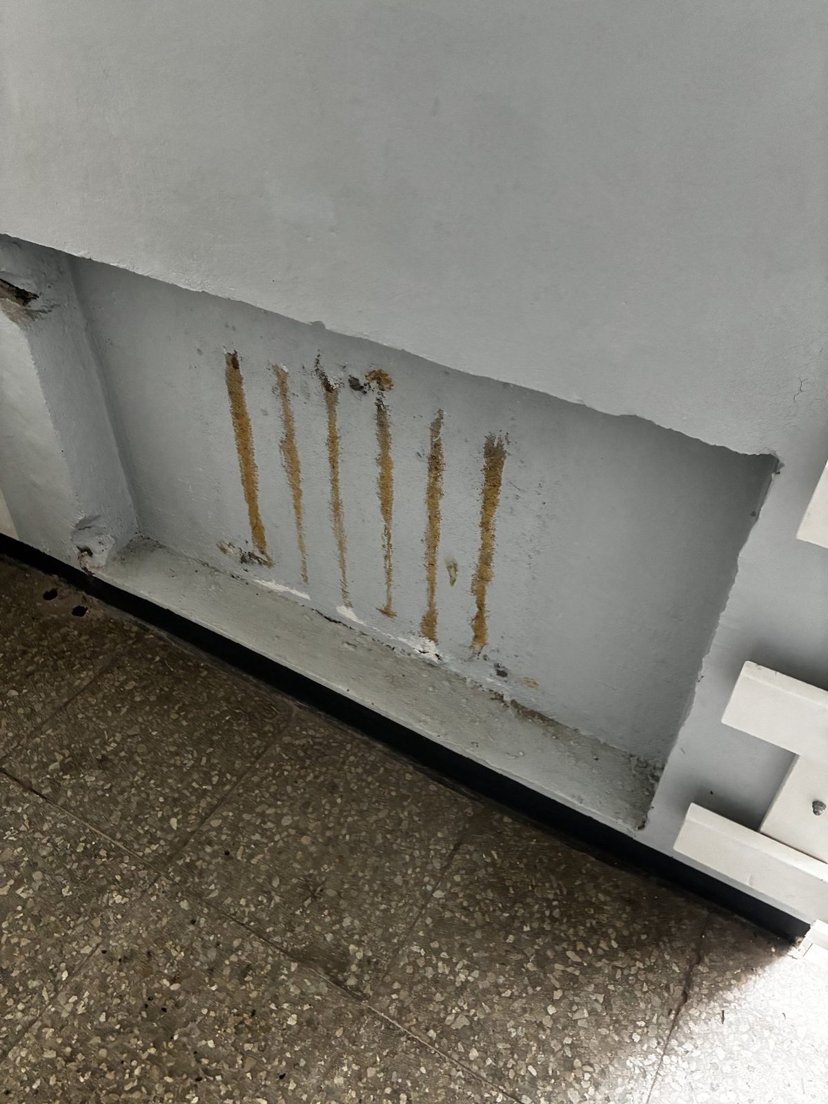 Existing radiator recess with visible rust and old fixing marks.