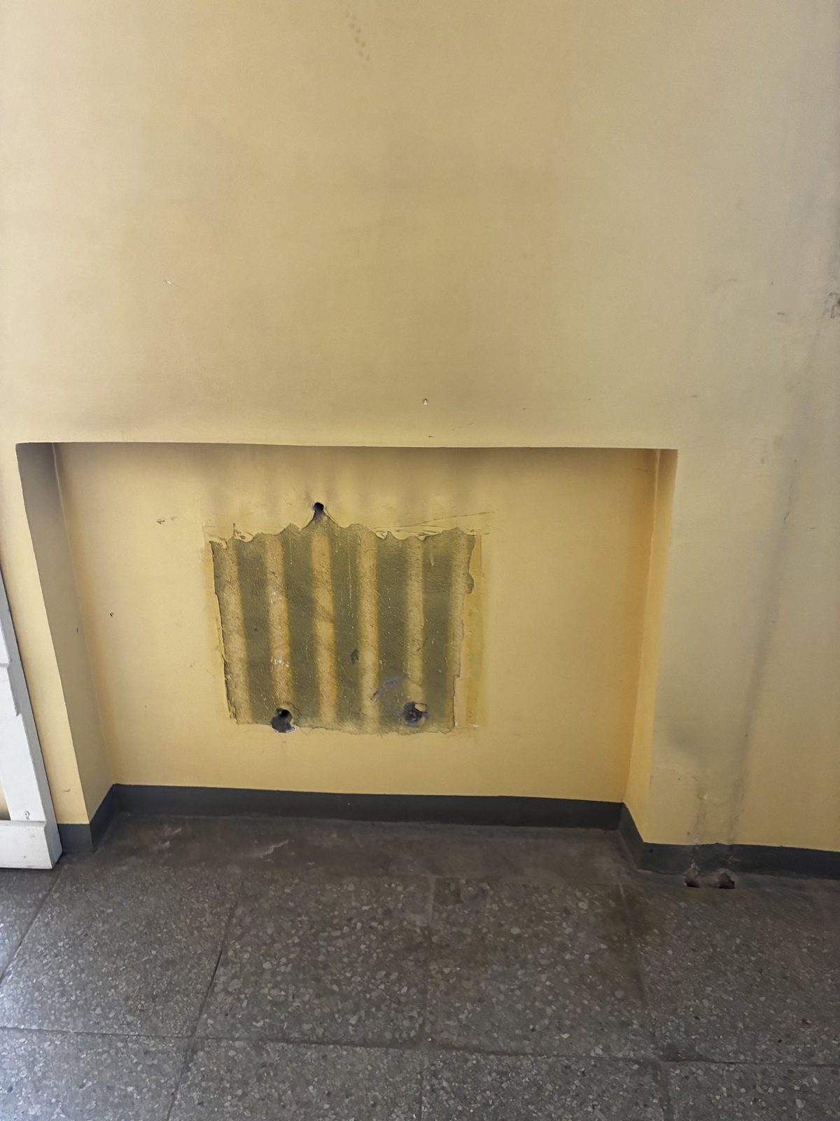 Wall section requiring repair before repainting.