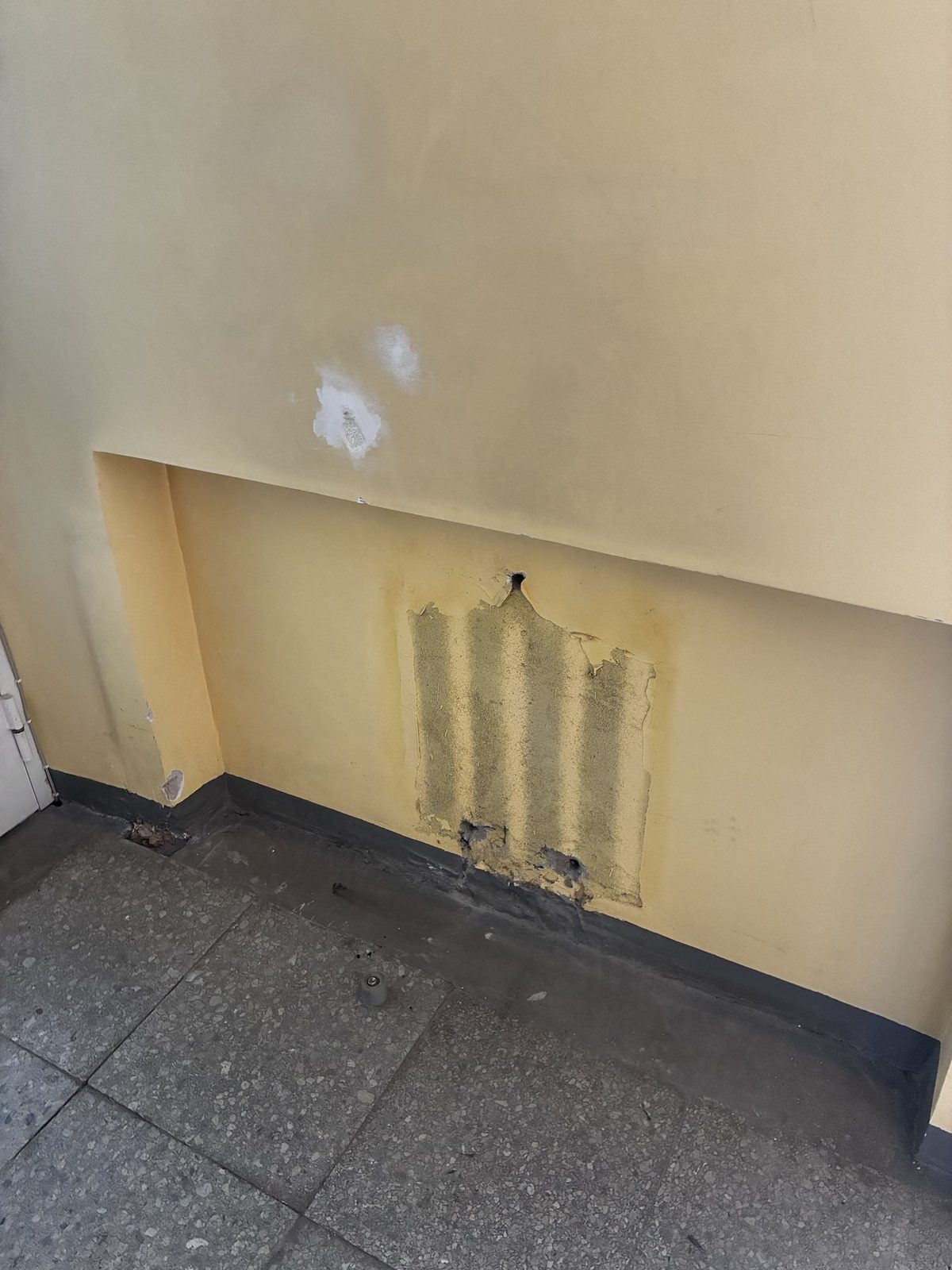 Old wall finish with local damage and uneven surface.