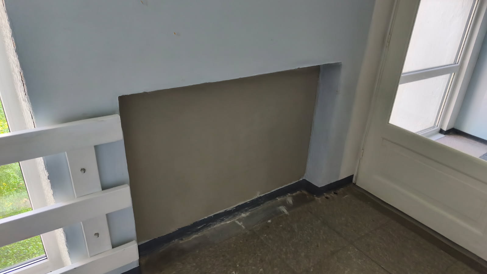 Wall repair in progress near the stairwell window.