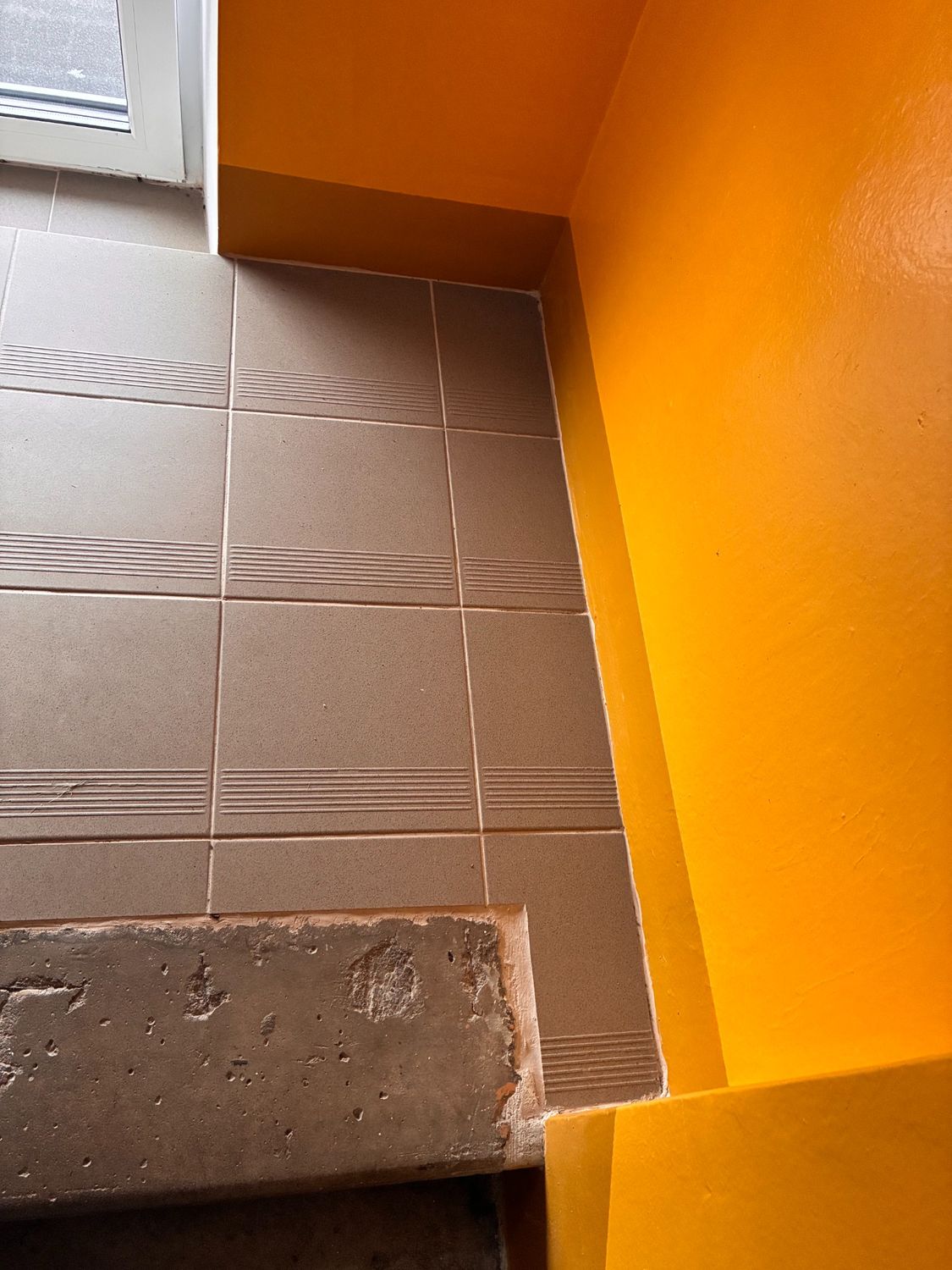 Finished tile junction and orange wall zone.