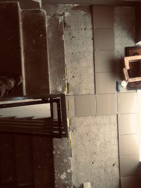 Tile installation during stairwell works.