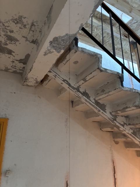 Damaged staircase ceiling before restoration.