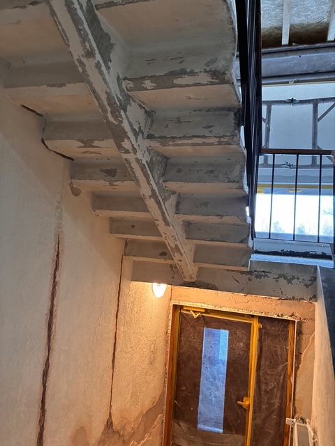 Concrete underside of staircase before repair.
