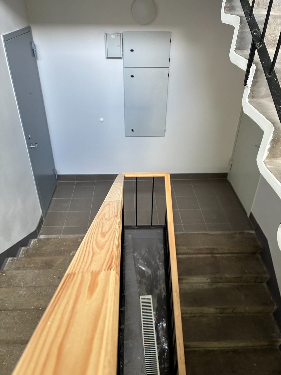 Completed stair landing with new handrail and cabinet doors.