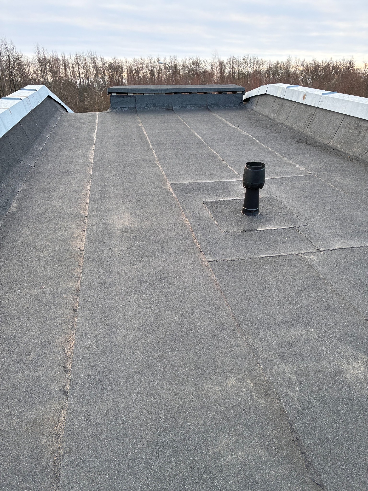 Completed roof overview with finished curb and parapets at Reinu tee 8